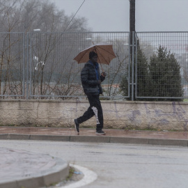 Una persona se protege de la lluvia en Alcalá de Henares, a 19 de enero de 2024.