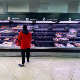 Una mujer observa los alimentos en los refrigeradores de carne de un supermercado de Mercadona, en Madrid.