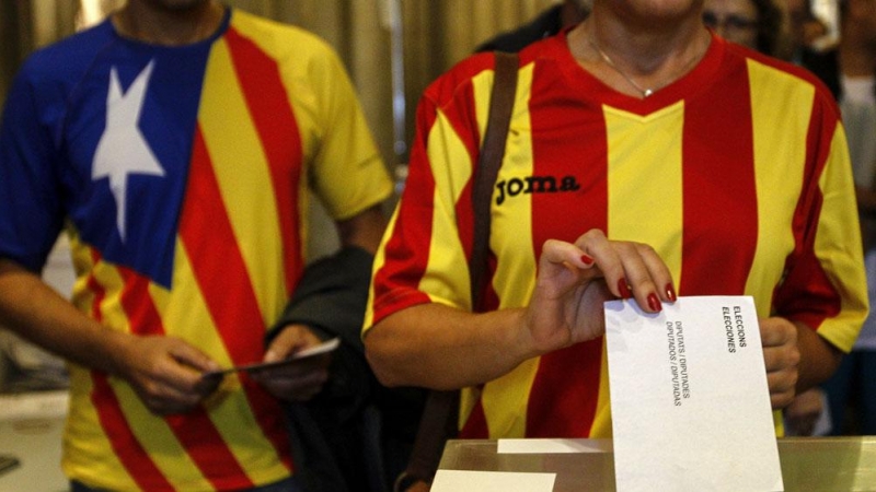 Una ciudadana deposita su voto en una mesa de en un colegio electoral de Barcelona, en las elecciones del 27-S. EFE/ Quique García