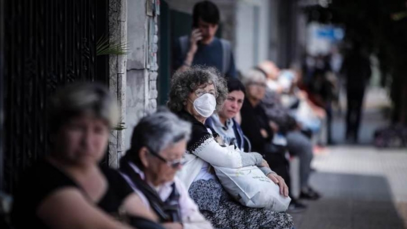 Personas que hacen fila afuera de un banco donde pagan jubilaciones y planes sociales este viernes, en Buenos Aires (Argentina). EFE/Juan Ignacio Roncoroni