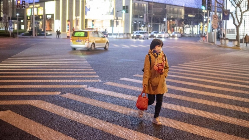Una mujer usa una mascarilla como protección contra el coronavirus mientras cruza una intersección limpia del centro comercial de lujo Reel en West Nanjing Road. EUROPA PRESS / ARCHIVO