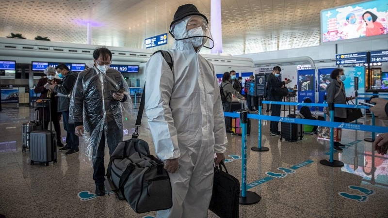 Los pasajeros con equipo de protección esperan en el aeropuerto internacional de Wuhan Tianhe después de que se levantó el bloqueo en Wuhan, China, el 8 de abril de 2020. EFE / ROMAN PILIPEY