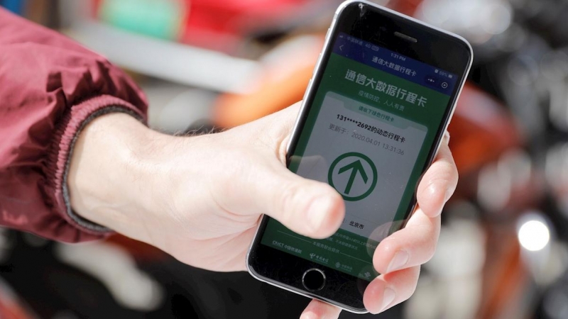 Un visitante muestra el código verde en su teléfono móvil a un guardia de seguridad mientras se prepara para ingresar a 798 Art Zone en Beijing, China, el 01 de abril de 2020. EFE / WU HONG