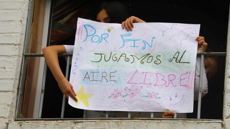 Niños despliegan una pancarta en una ventana de Córdoba. | EFE