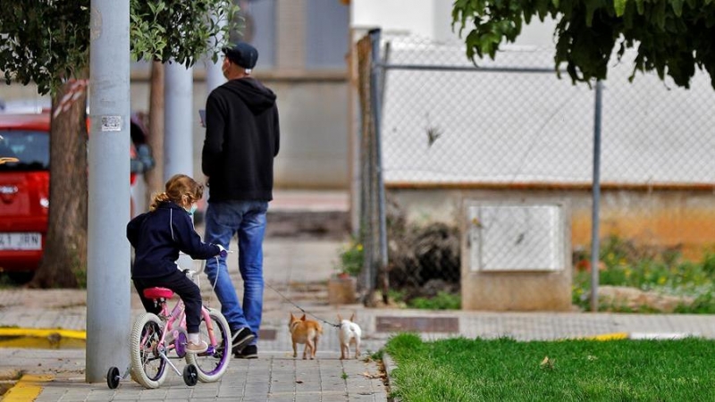 Un padre pasea junto a su hija y sus dos perros en Valencia | EFE