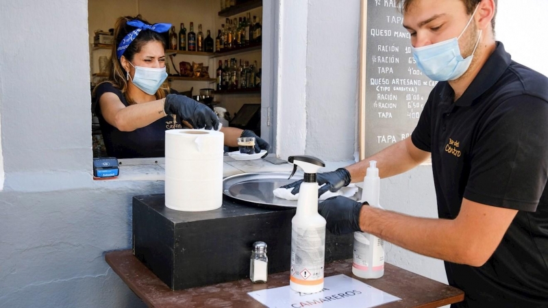 04/05/2020.- Los camareros limpian la bandeja para servir en una cafetería abierta en Formentera este lunes. / EFE -  Sergio G. Canizares