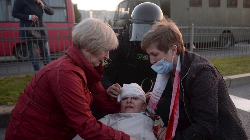 Mujeres y un policía ayudan a un manifestante herido durante una manifestación para protestar contra la toma de posesión de Alexander Lukashenko. EFE / EPA / STR