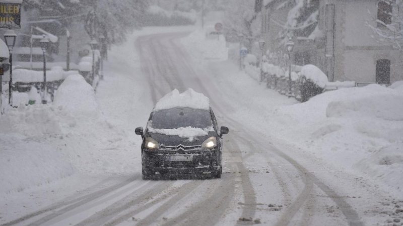 Un coche circula por una carretera en el Pirineo aragonés, en Huesca, Aragón (España), a 29 de diciembre de 2020. La alerta roja por nieve tras la borrasca Bella se mantiene este martes en 14 carreteras del Pirineo aragonés, donde es obligatorio el uso de