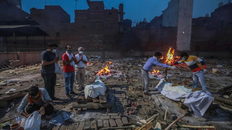 Imagen de archivo de varias personas incinerando a fallecidos por la covid-19, en India. - EFE
