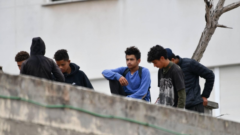 Varios menores migrantes, en el tejado de una nave industrial, a 27 de agosto de 2021, en Ceuta, (España).