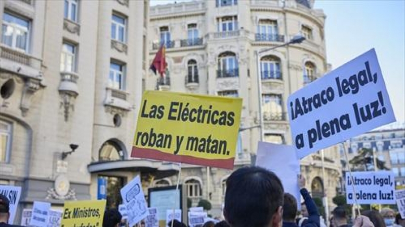 Asistentes sostienen pancartas en una manifestación contra la subida del precio de la luz, a 23 de octubre de 2021, en Madrid.