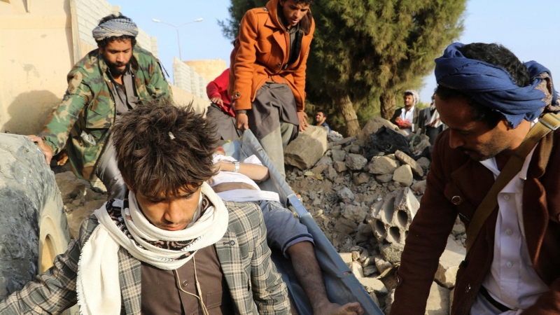 22/01/2022 Varios hombres sacan de entre los escombros a un hombre herido en el atentado contra un centro de detención en la ciudad yemení de Saada