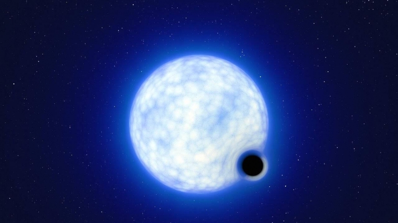 Ilustración del sistema binario VFTS 243, compuesto por una estrella azul caliente y un agujero negro. Los tamaños no son a escala, ya que las estrella es unas 200 000 veces más grande que el agujero.