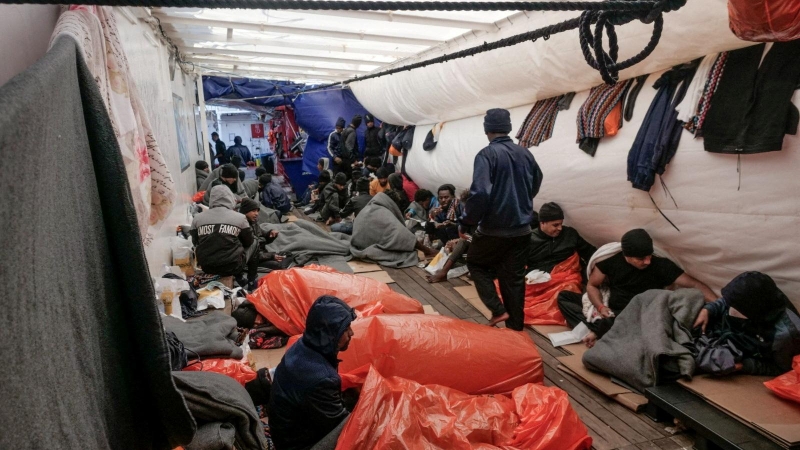 Migrantes intentan dormir en la cubierta del barco de rescate 'Ocean Viking' en el Mediterráneo a la espera de un puerto para desembarcar el pasado 6 de noviembre de 2022.
