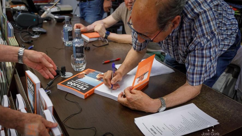 18/8/23 Manuel Monge firma ejemplares de su libro durante una presentación.