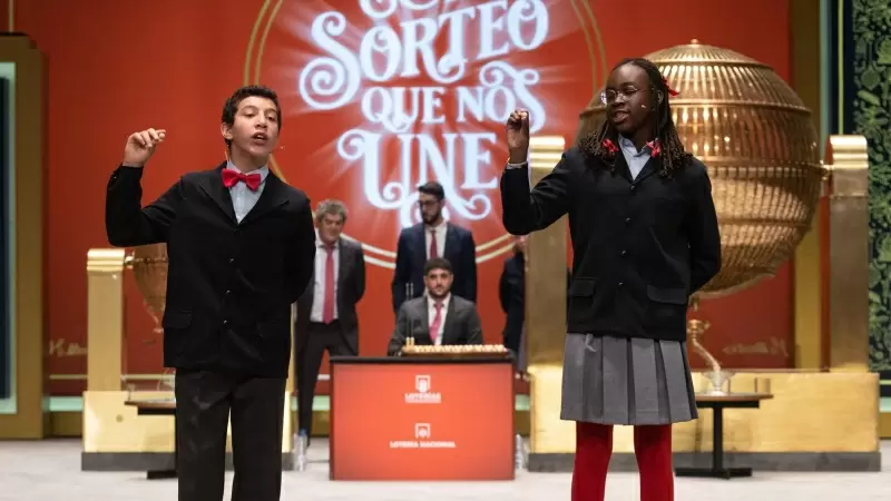 Dos niños de la residencia de San Ildefonso cantan un cuarto premio del Sorteo Extraordinario de la Lotería de Navidad, a 22 de diciembre de 2022, en Madrid.