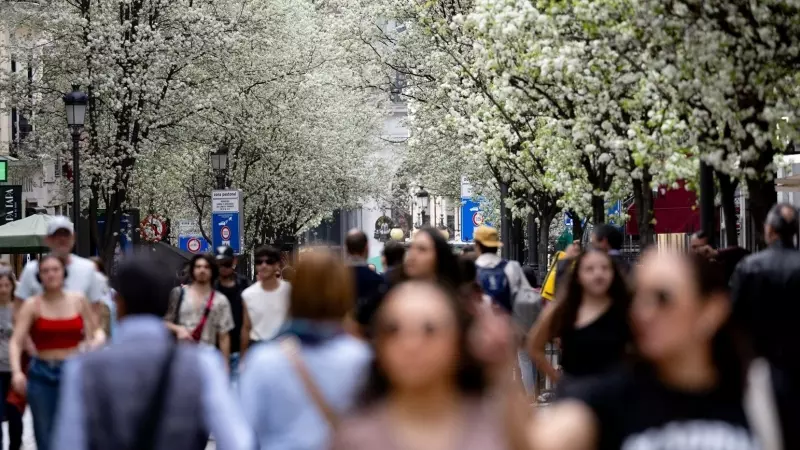 Varias personas pasean junto a árboles en flor durante el primer día de primavera, a 20 de marzo de 2024, en Madrid.