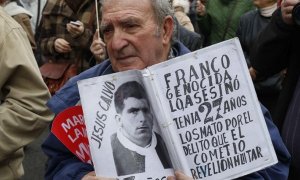 Un hombre muestra una foto de una víctima del franquismo. EFE/Paco Campos