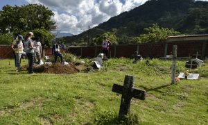 Miembros del Comité Internacional de la Cruz Roja (CICR) trabajan en la recuperación de los restos mortales de asesinados durante el conflicto armado en Colombiam en un cementerio en la jungla del Catatumbo. - AFP