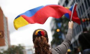 Una mujer ondea una bandera de Venezuela durante una manifestación en contra de Nicolás Maduro. / REUTERS - ANDRES MARTINEZ CASARES