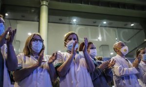 El personal sanitario sale de la clínica de un hospital para recibir los aplausos del público todas las tardes. / EUROPA PRESS