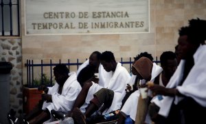 Varios inmigrantes desayunan mientras son atendidos por los servicios sanitarios tras conseguir saltar la valla, que separa la ciudad autónoma de Melilla de Marruecos, este lunes. EFE/F.G. Guerrero