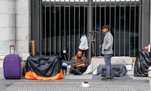 Dos hombres sin hogar durante el primer día de la cuarta semana de estado de alarma decretado por el Gobierno para combatir el coronavirus, en Madrid.  Europa Press / Óscar J.Barroso