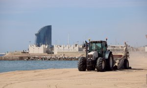 Un tractor en la represa del servei de neteja de les platges a Barcelona, a la platja del Bogatell, el 7 de maig del 2020. (Horitzontal)