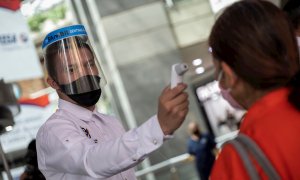 23/06/2020.- Un oficial de seguridad toma la temperatura de una usuaria de un Centro Comercial Sambil en Caracas (Venezuela). EFE/ Rayner Peña R./Archivo