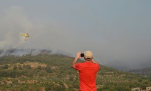 Un vecino de la localidad de Aldeanueva de la Vera (Cáceres) otografía los trabajos de extinción del incendio forestal declarado en Cabezuela del Valle, en la comarca cacereña del Valle del Jerte. / EFE/ Eduardo Palomo