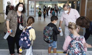 Personal del colegio Aldapeta María Ikastetxea aplica este lunes gel hidroalcohólico a los alumnos. EFE/ Juan Herrero