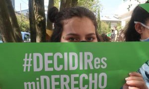 Una mujer sostiene un cartel mientras se manifiesta a favor de la despenalización del aborto hoy en Quito.