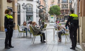 Una patrulla de la Policía Local mide las distancias de las mesas de una terraza en el casco viejo de Zaragoza.