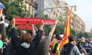 Diversos manifestants mostrant rètols de protesta contra el rei Felip VI davant l'Estació de França.