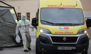 Un sanitario completamente protegido accede a una ambulancia junto al área donde soldados del Mando de Ingenieros de Salamanca del Ejército de Tierra