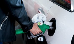 Una mujer pone gasolina a su vehículo en una gasolinera.