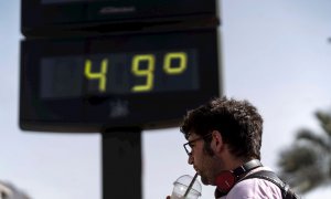 Un hombre toma una bebida junto a un termómetro de Córdoba en otra jornada marcada por la ola de calor en la que hay previsiones de que las temperaturas alcancen los 47 grados en el Valle del Guadalquivir.