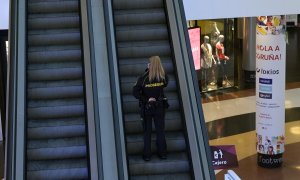 Una vigilante de PROSEGUR sube las escaleras del centro comercial Marineda, en A Coruña.