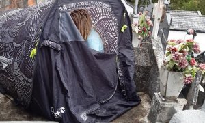 Mujer acampada sobre un nicho en el cementerio de San Lázaro en Lugo, Galicia, el pasado 2 de octubre.