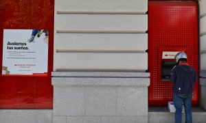 Un hombre opera en un cajero automático de una oficina del Banco Santander en Madrid. GABRIEL BOUYS / AFP