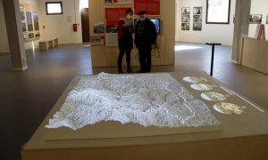 Dos visitants mirant el mapa de relleu dels Pirineus a la Verneda de Prats de Molló.