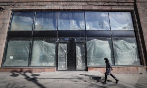 Una mujer rusa camina frente a las ventanas de un espacio comercial vacío en el centro de Moscú, Rusia, el 15 de marzo de 2022.