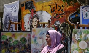 19/05/2022-Una mujer se encuentra este viernes 19 de mayo delante de un mural, que forma parte de una exposición de arte en honor a la periodista Shireen Abu Akleh, en el lugar donde fue asesinada