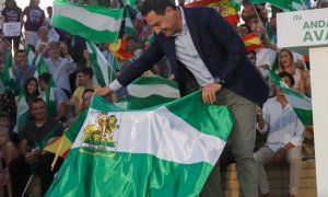 Juanma Moreno torea con una bandera de Andalucía en el inicio de la campaña a los comicios al Parlamento.