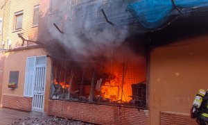 Les flames en l'incendi d'un local a Sant Adrià de Besòs que ha deixat 13 persones ferides per inhalació de fum.
