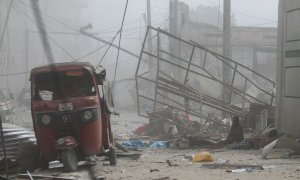 Un hombre sentado entre los escombros tras la explosión de un coche bomba frente al Ministerio de Educación en Mogadiscio, Somalia, a 29 de octubre de 2022