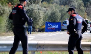 Dos agentes de los Mossos a la altura de la carretera N-420 donde se ha encontrado el cuerpo de la joven a 23 de marzo de 2023