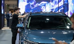 Un joven frente a un vehículo en una imagen de archivo tomada antes del inicio del Automobile Barcelona 2023, a 11 de mayo de 2023