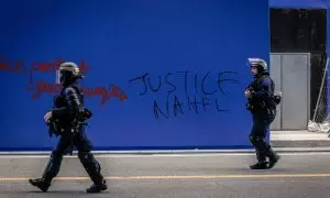 Policías antidisturbios frente a una pintada pidiendo "Justicia para Nahel" en París, Francia