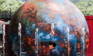 05/07/2023.- Un hombre camina frente a una instalación que muestra una Tierra en llamas en un parque en Daegu, Corea del Sur, a 5 de julio 2023.